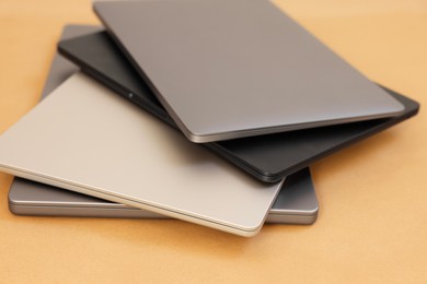 Photo of Different modern laptops on brown background, closeup