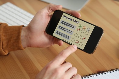 Photo of Man taking online test on smartphone at desk, closeup