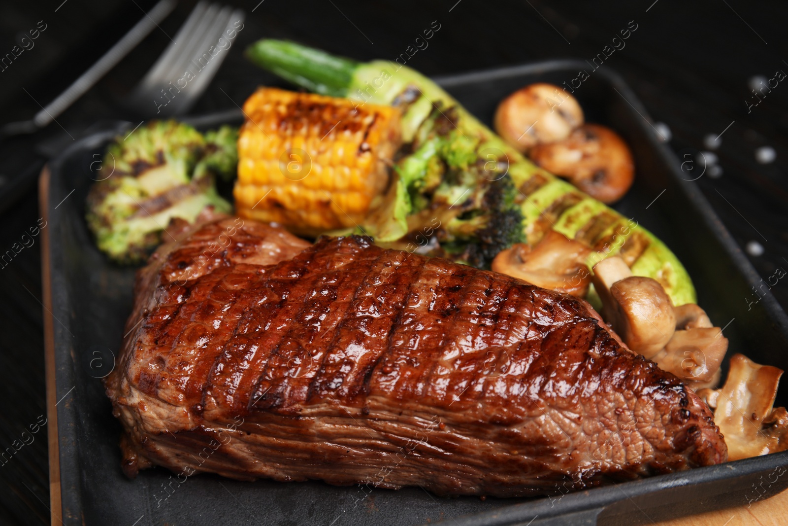 Photo of Delicious grilled beef tenderloin served on table, closeup