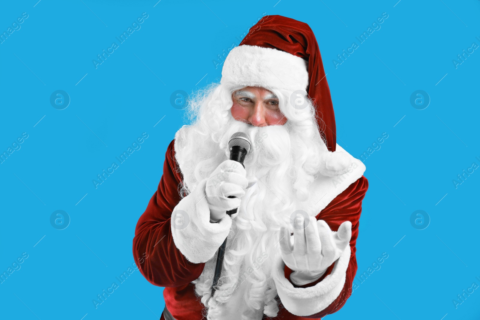 Photo of Santa Claus singing with microphone on blue background. Christmas music