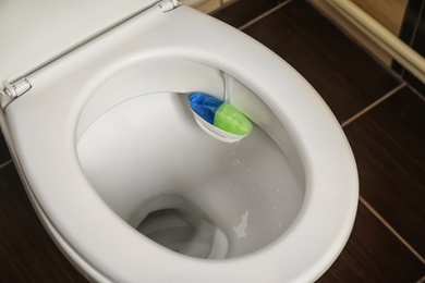 Photo of Toilet with rim block in bathroom. Air freshener