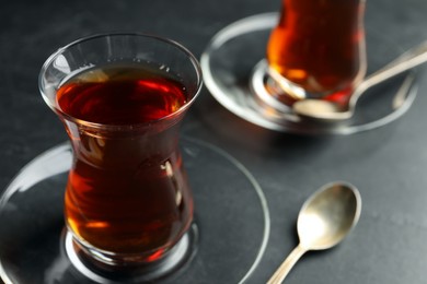 Photo of Glasses with traditional Turkish tea on black table, closeup