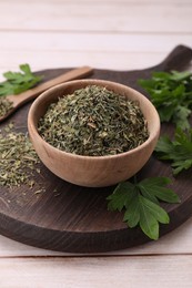 Dried aromatic parsley and fresh leaves on white wooden table