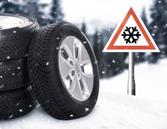 Set of wheels with winter tires on snow and road sign outdoors