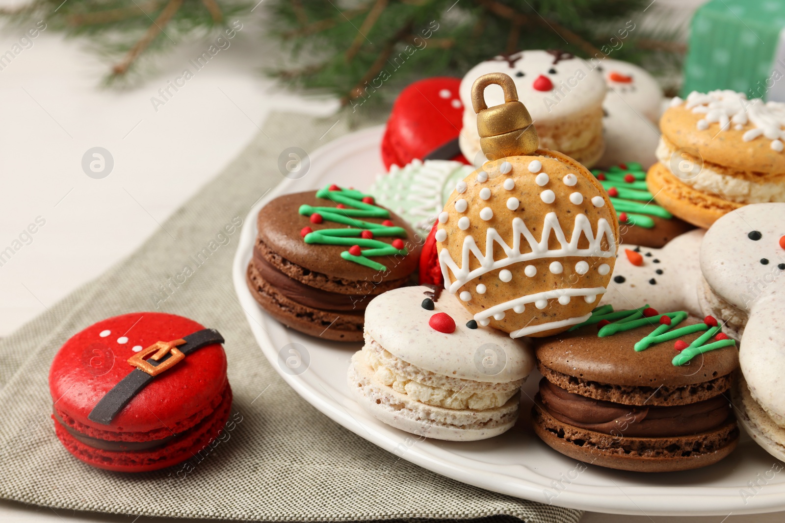 Photo of Beautifully decorated Christmas macarons on white table, closeup