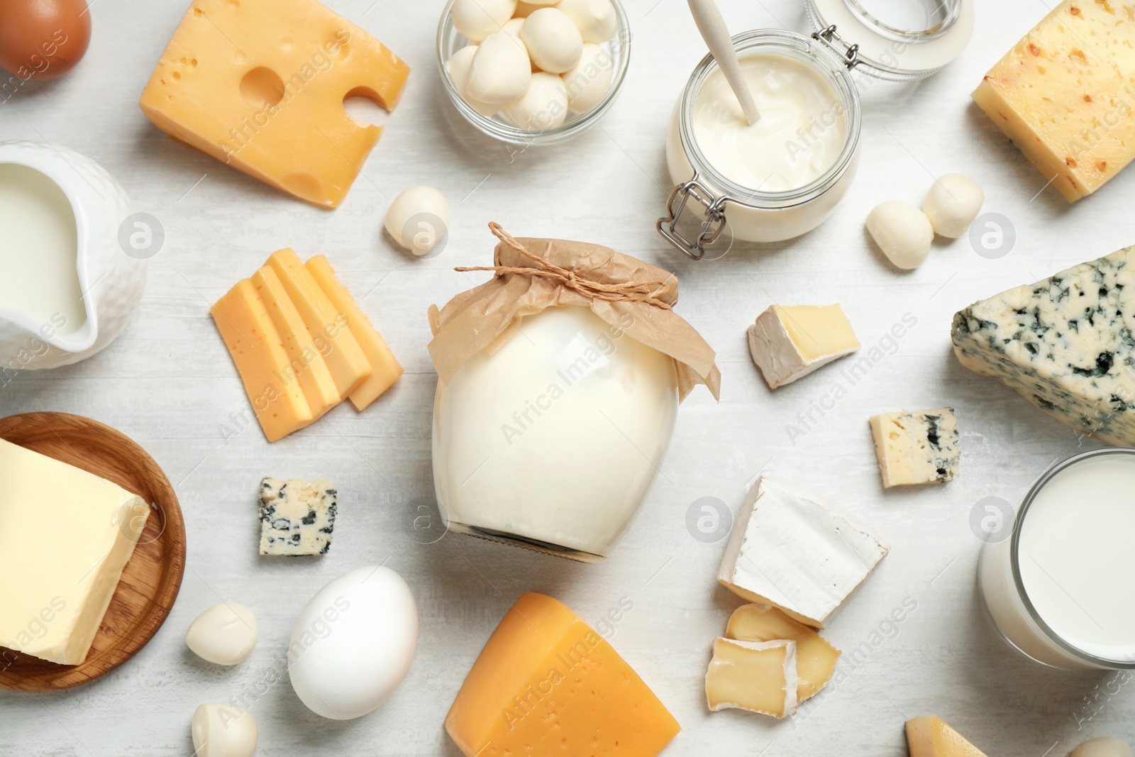 Photo of Different delicious dairy products on white table, flat lay