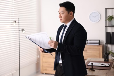 Portrait of confident notary with clipboard in office