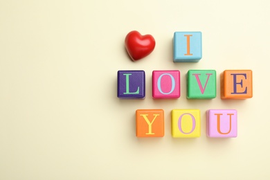 Phrase I love You made of color cubes on light background, flat lay. Space for text