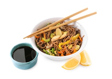 Photo of Stir-fry. Delicious cooked noodles with chicken in bowl, soy sauce, lemon and chopsticks isolated on white