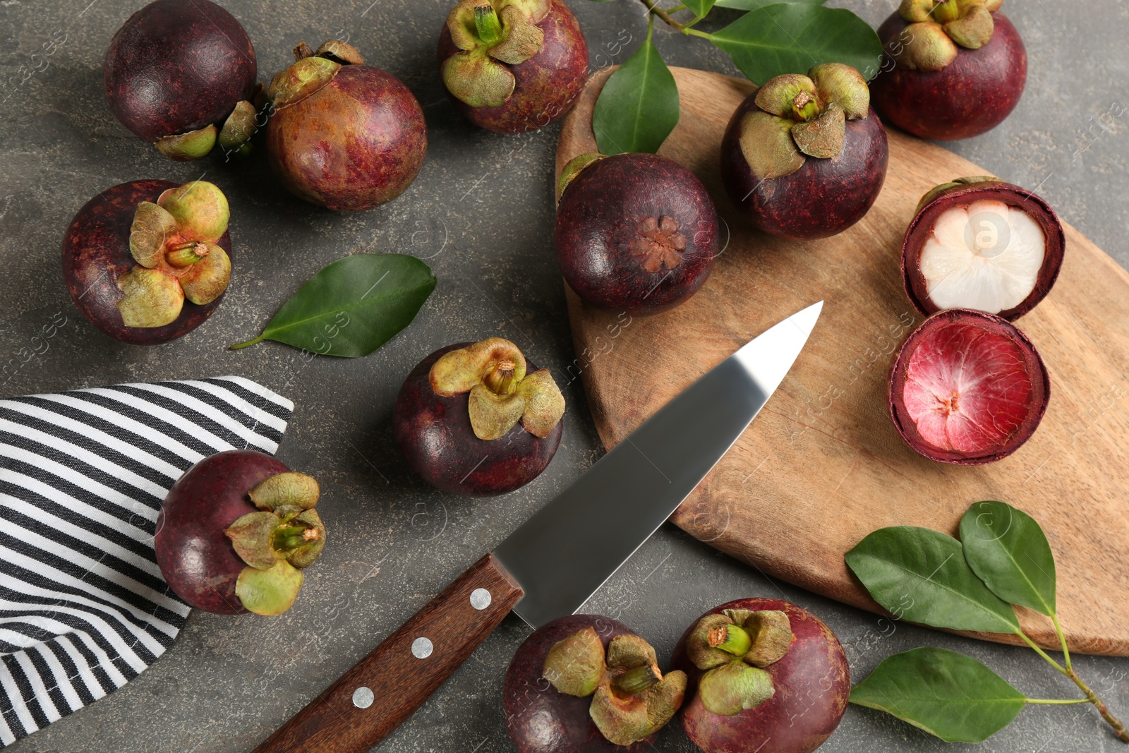 Photo of Fresh ripe mangosteen fruits on grey table, flat lay