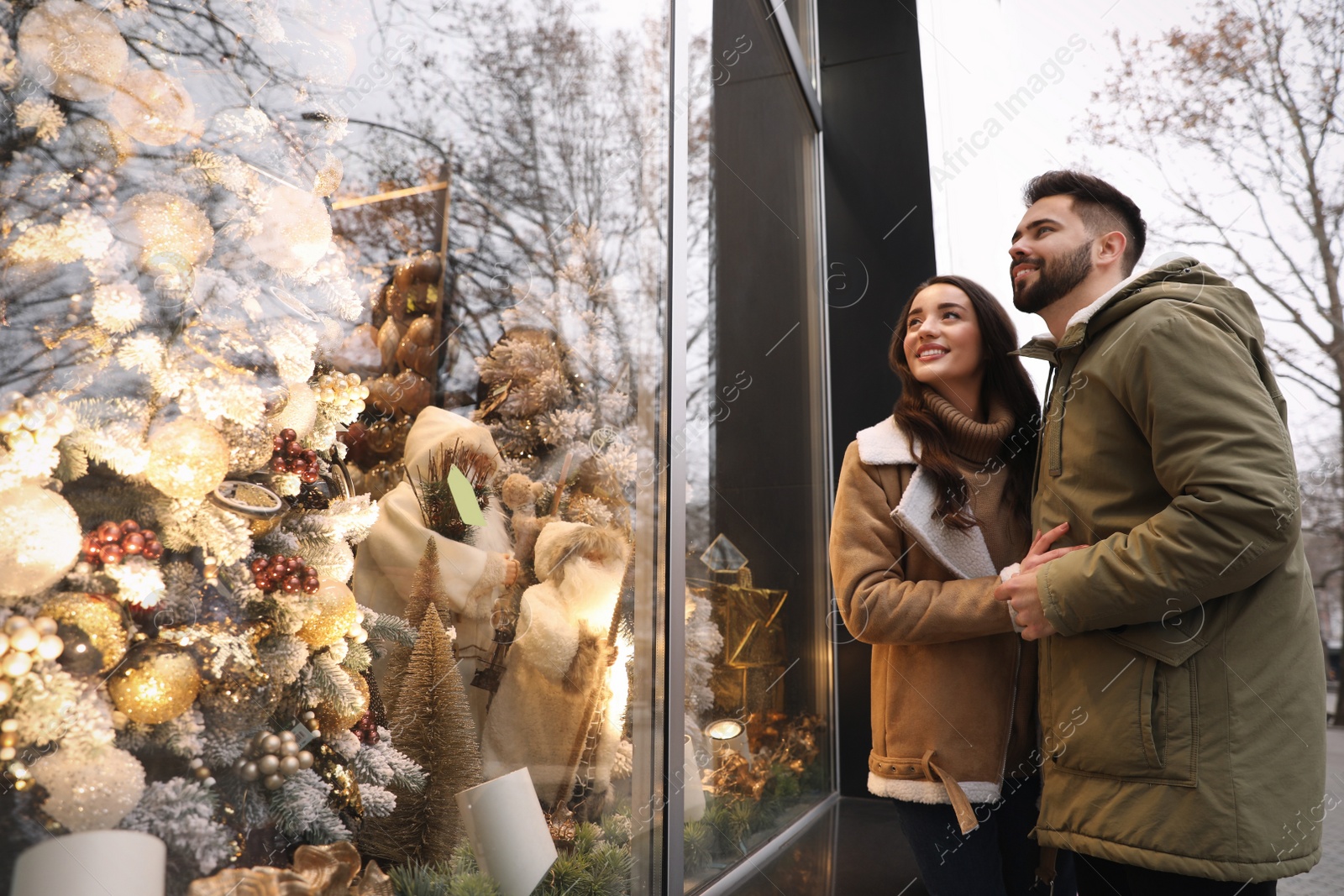 Photo of Lovely couple near store decorated for Christmas outdoors