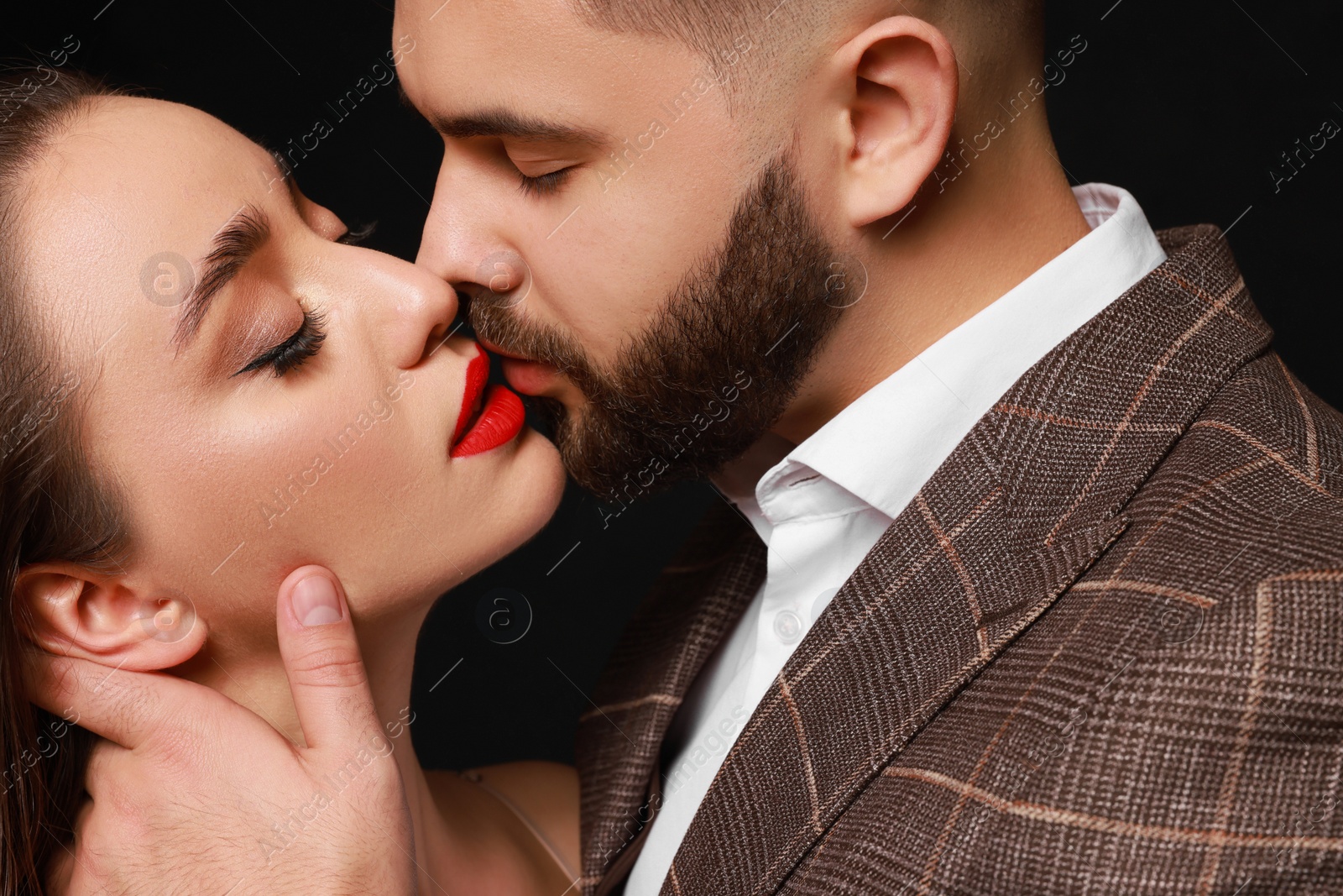 Photo of Handsome bearded man with sexy lady on black background, closeup