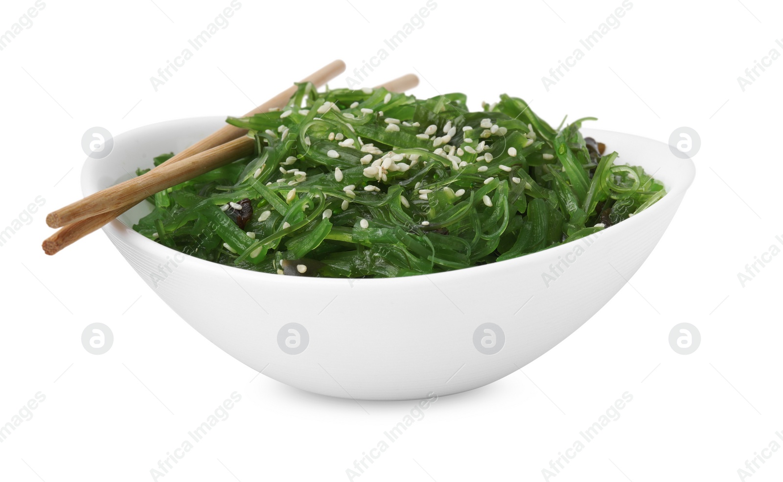 Photo of Tasty seaweed salad in bowl and chopsticks isolated on white