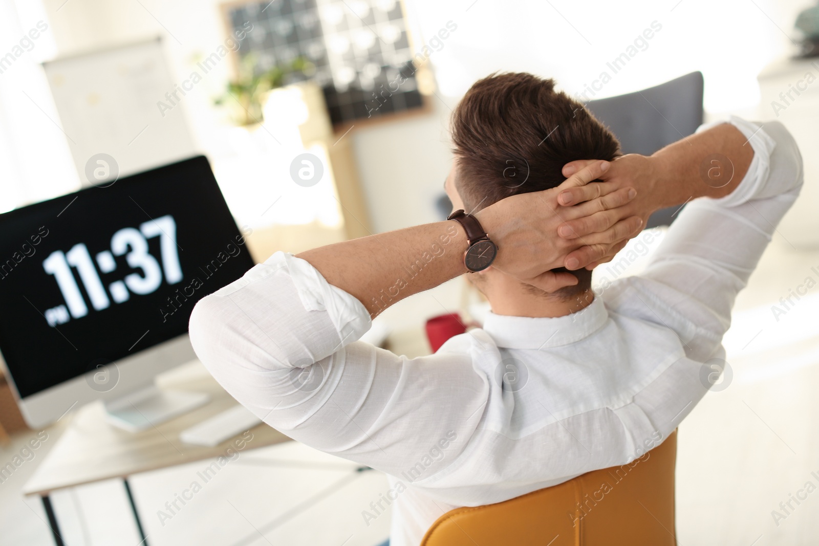 Photo of Young businessman relaxing at table in office during break