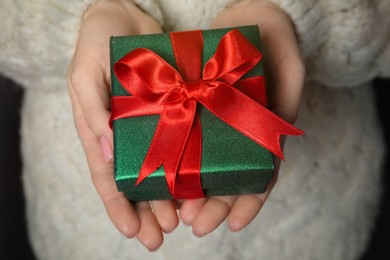 Photo of Christmas present. Woman holding beautifully wrapped gift box, closeup