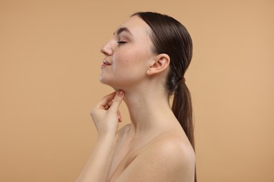 Photo of Beautiful woman touching her chin on beige background