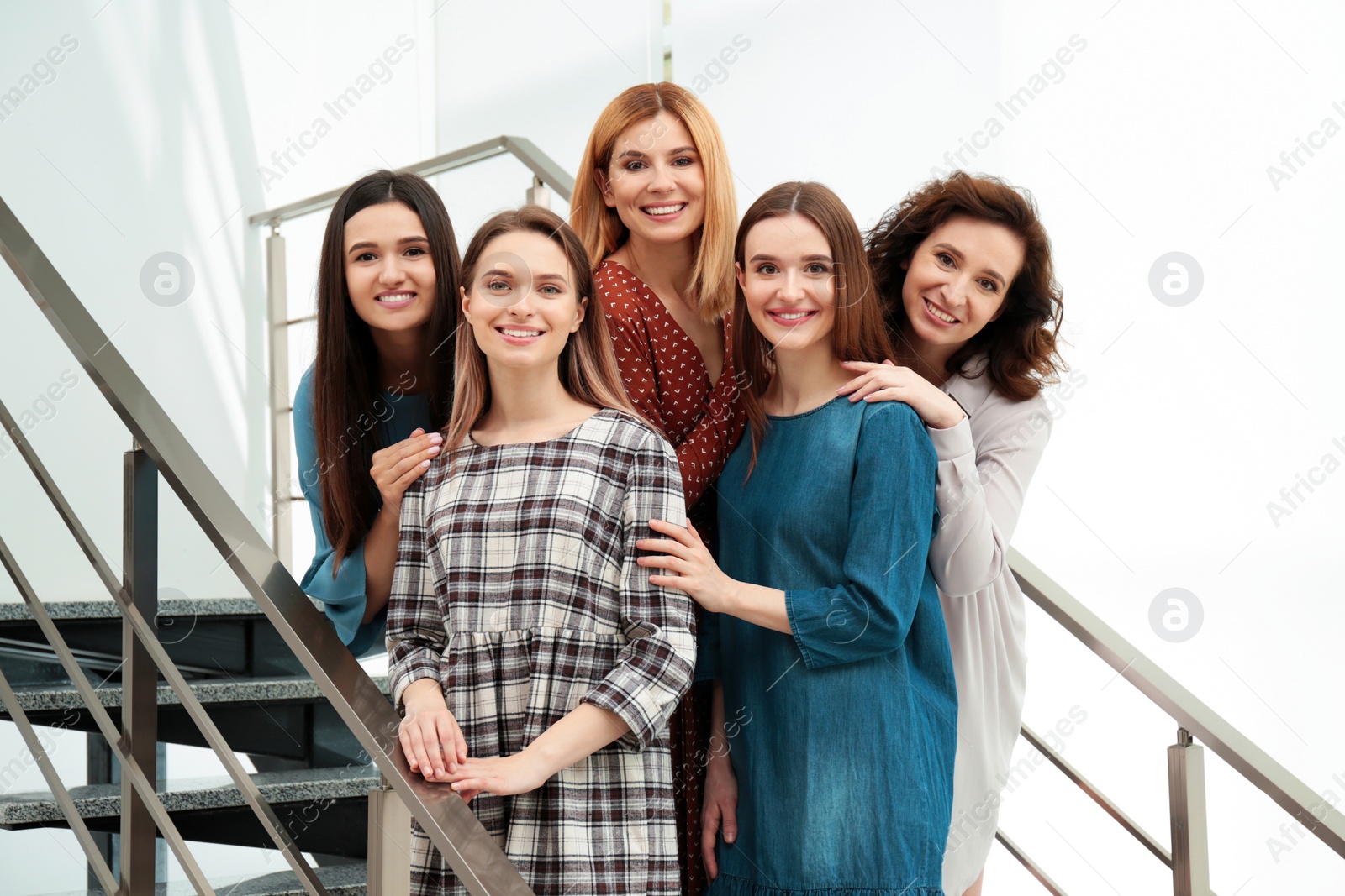 Photo of Portrait of happy ladies on stairs indoors. Women power concept