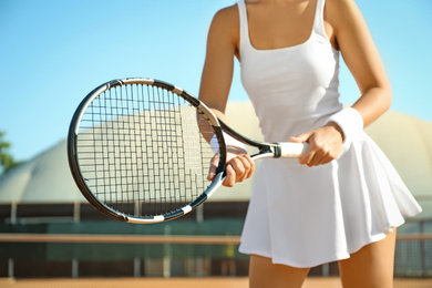 Sportswoman playing tennis at court on sunny day, closeup