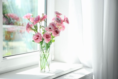 Photo of Glass vase with beautiful flowers on window sill in room, space for text