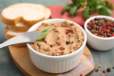 Delicious meat pate with spices, fresh bread and knife on blue wooden table, closeup