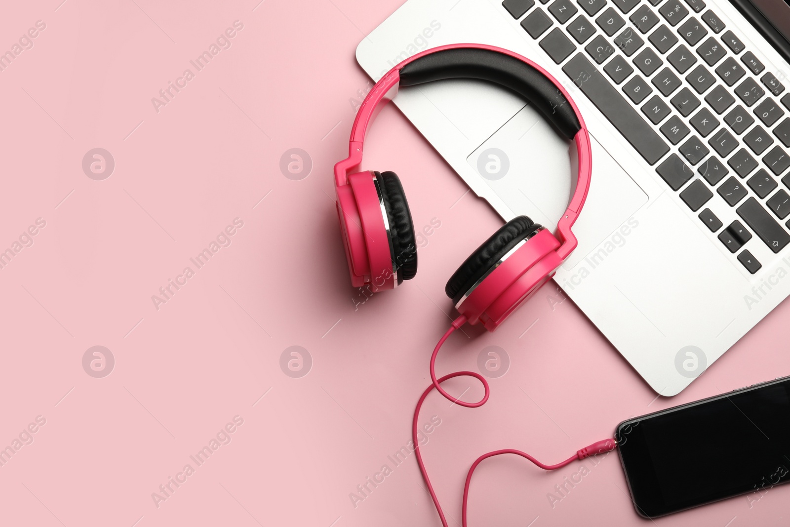 Photo of Modern headphones, phone and laptop on color background, flat lay. Space for text