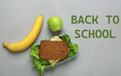 Lunch box with tasty sandwich and fruits on light grey background, top view