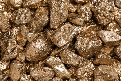 Photo of Many gold nuggets as background, top view