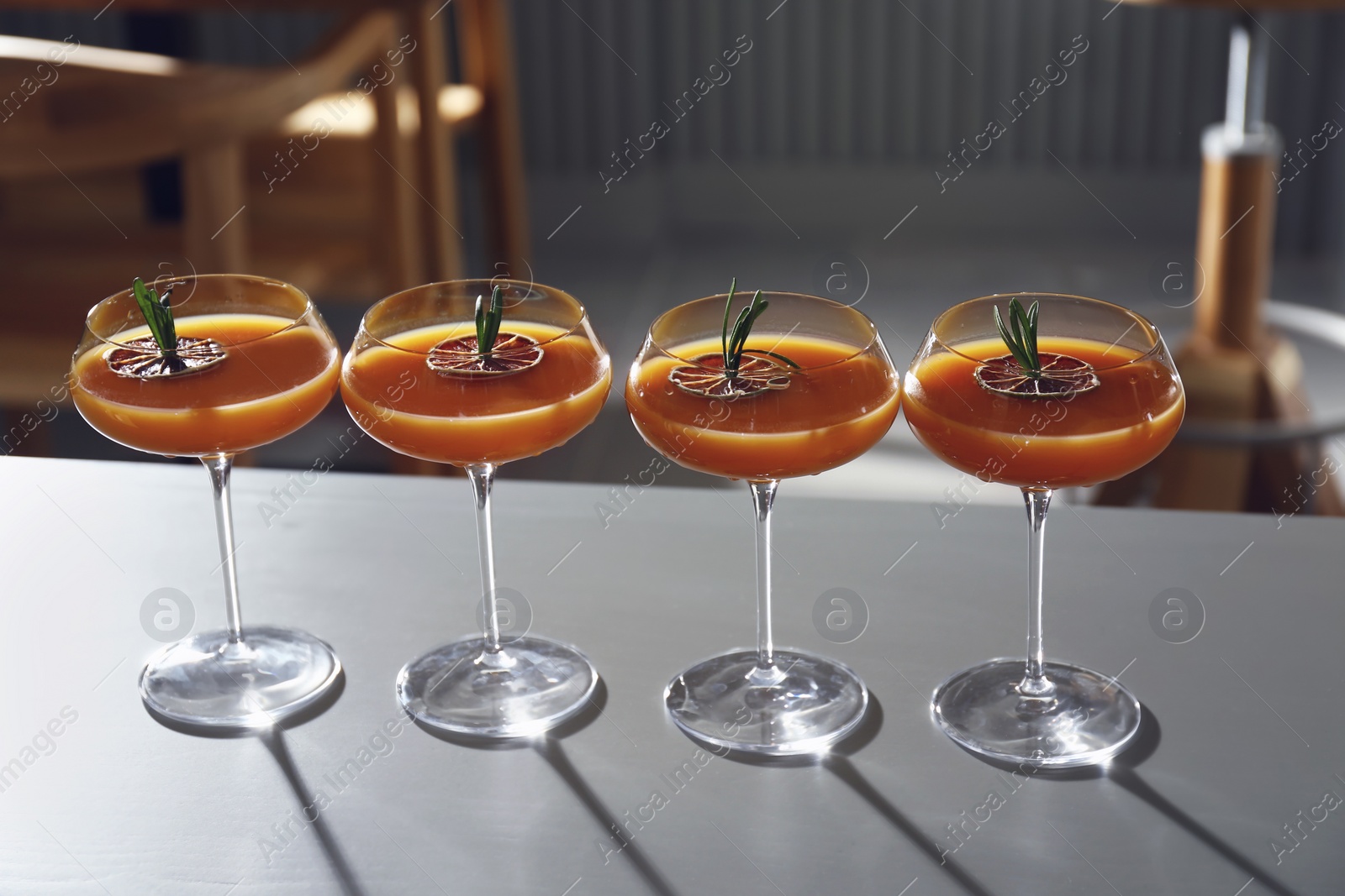 Photo of Glasses of delicious cocktail with vodka on table in bar