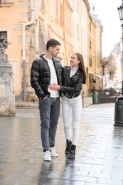 Photo of Lovely young couple walking together on city street. Romantic date