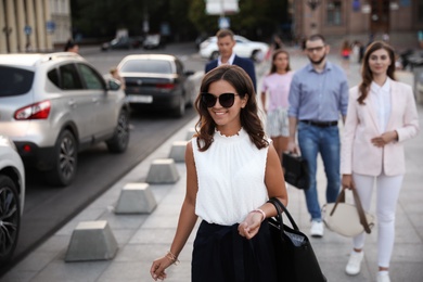 Photo of Young woman walking on modern city street