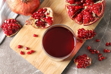 Photo of Flat lay composition with pomegranate juice, fruit and seeds on table