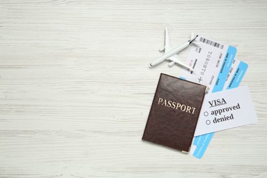 Photo of Passport, toy plane and tickets on white wooden background, flat lay with space for text. Visa receiving