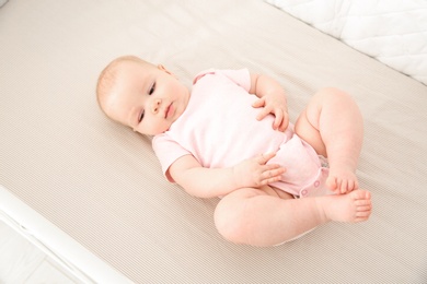 Photo of Cute baby girl in crib. Bedtime schedule