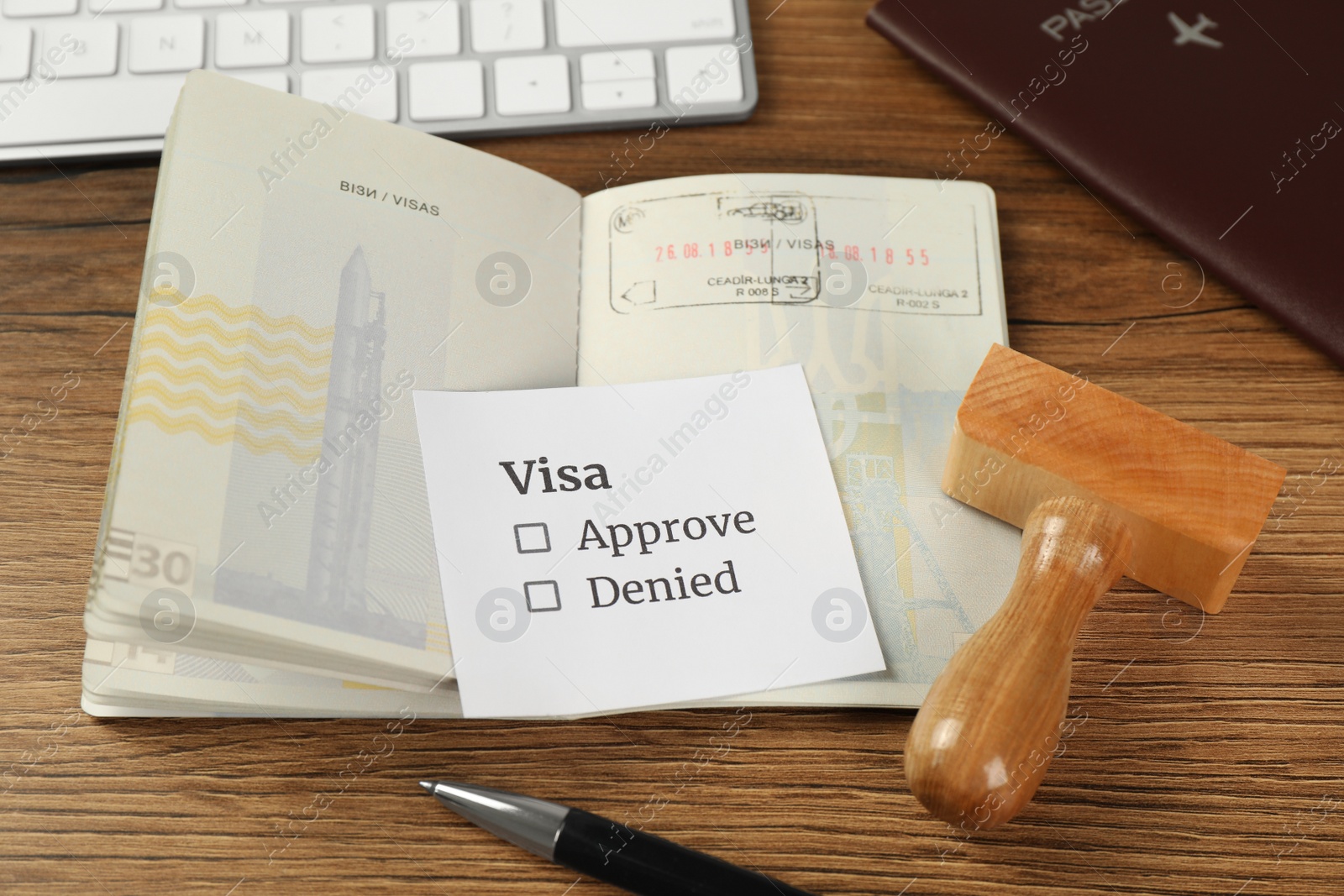 Photo of Moldova, Ceadir-Lunga - June 13, 2022: Passport with visa stamps on wooden table