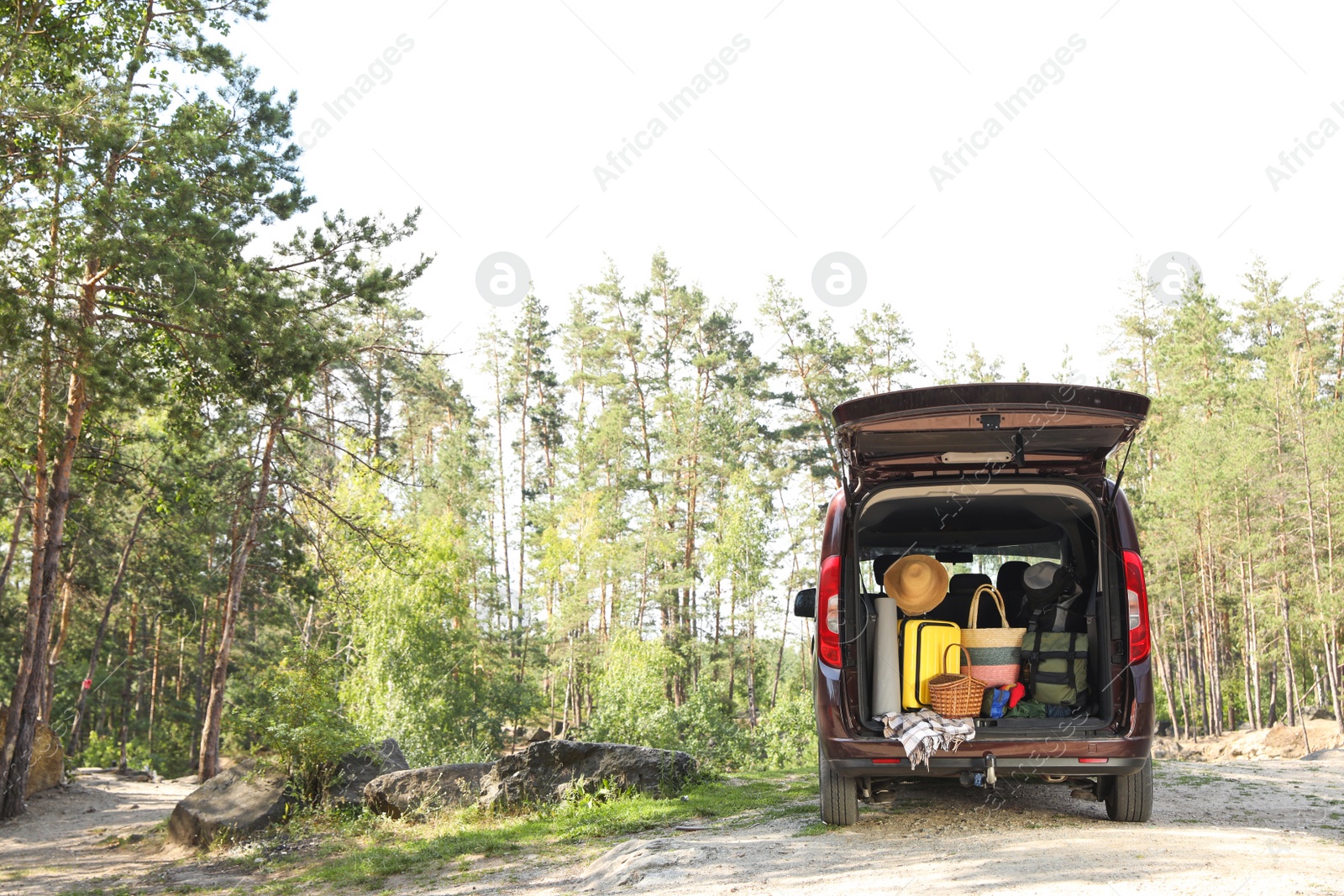 Photo of Van with camping equipment in trunk outdoors