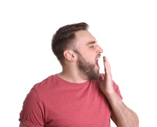 Photo of Sleepy young man yawning on white background