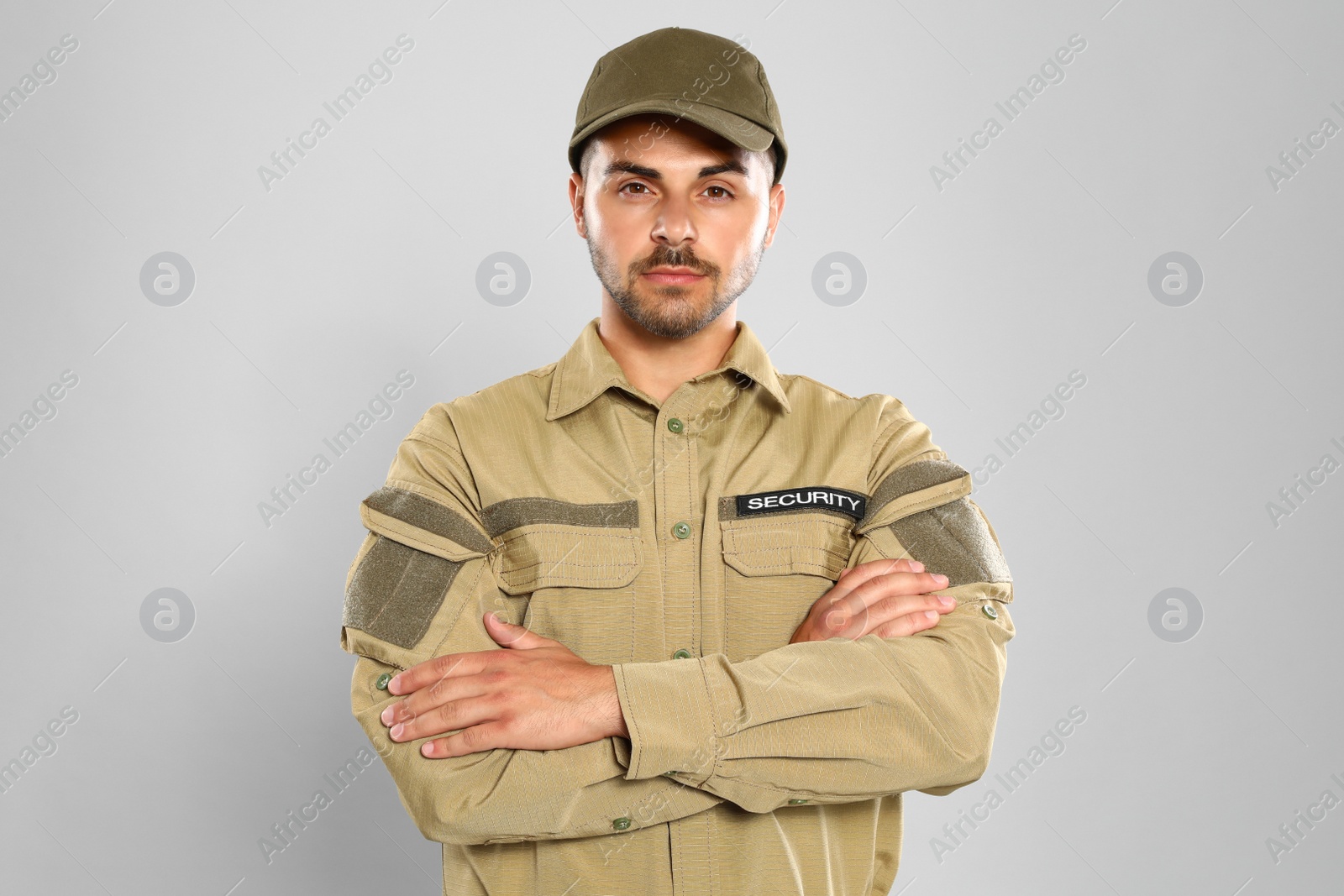 Photo of Male security guard in uniform on grey background