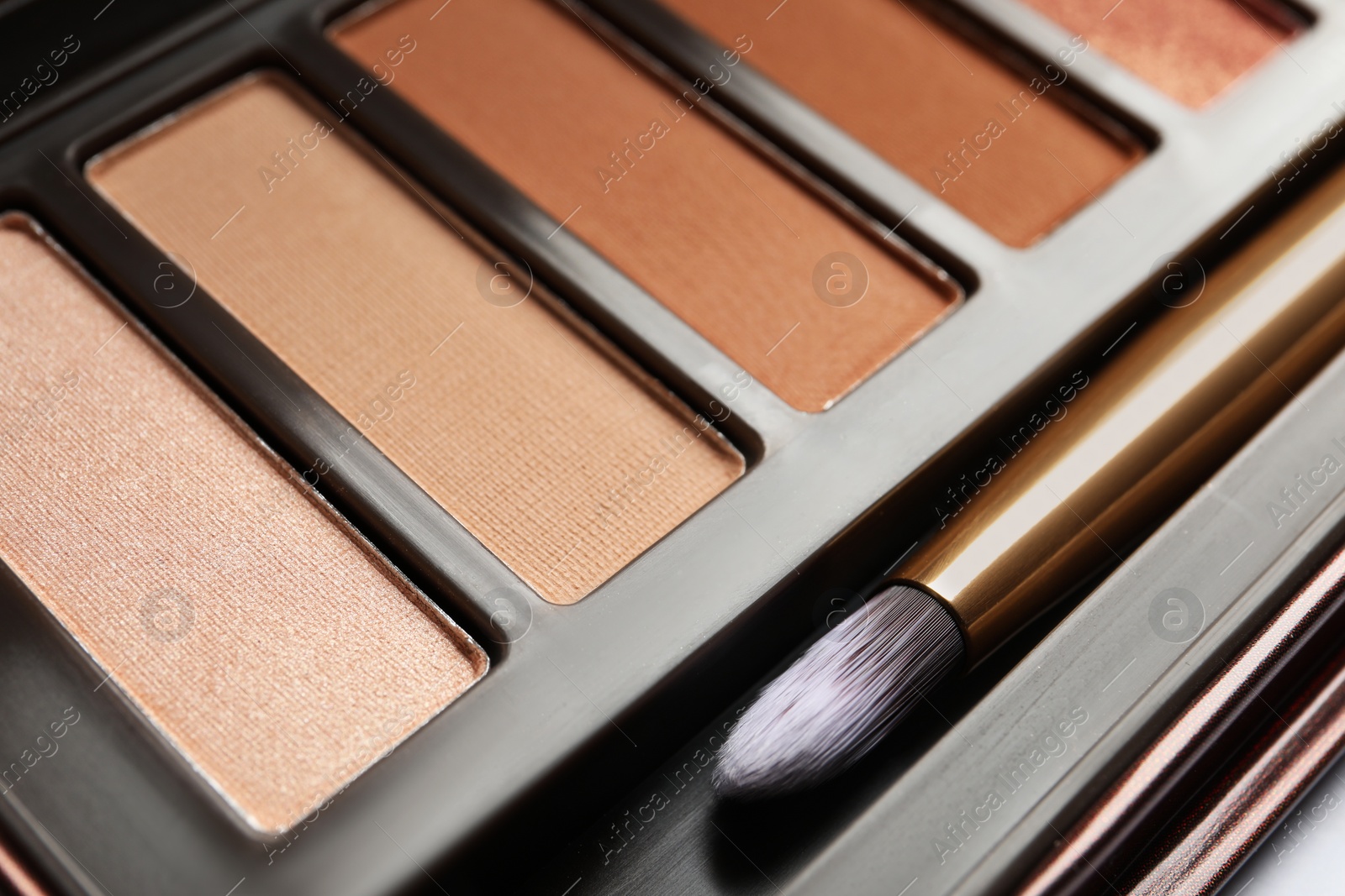 Photo of Beautiful eye shadow palette with brush on white table, closeup