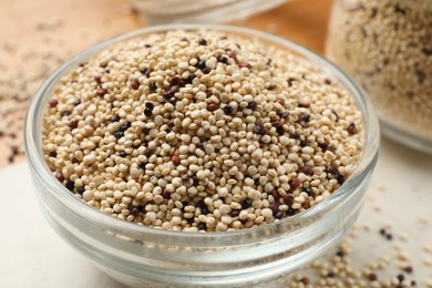 Photo of Raw quinoa seeds in bowl on table, closeup