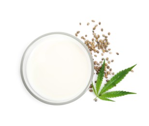 Photo of Glass of fresh hemp milk, seeds and leaf on white background, top view