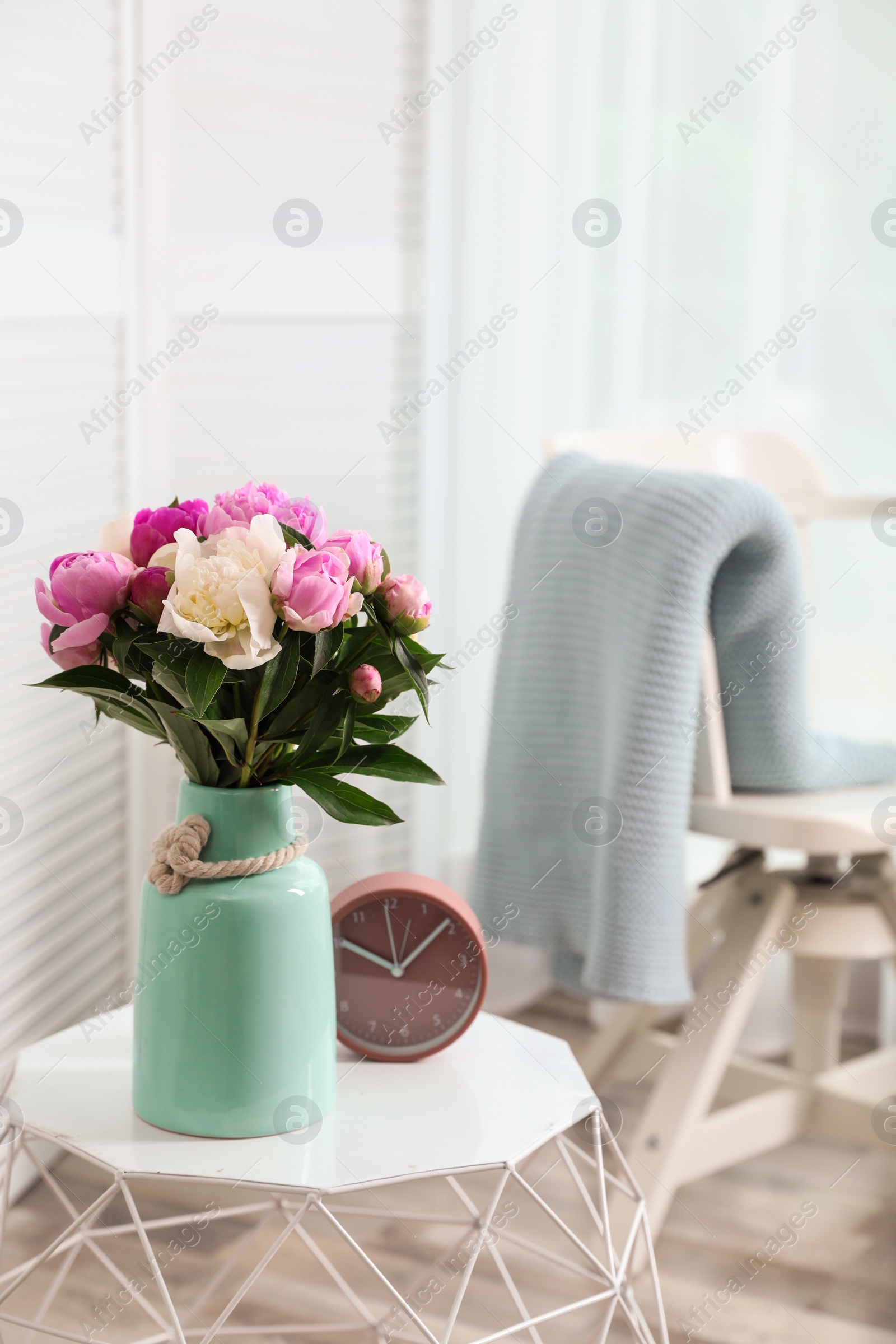 Photo of Vase with bouquet of beautiful peonies on table in room. Space for text