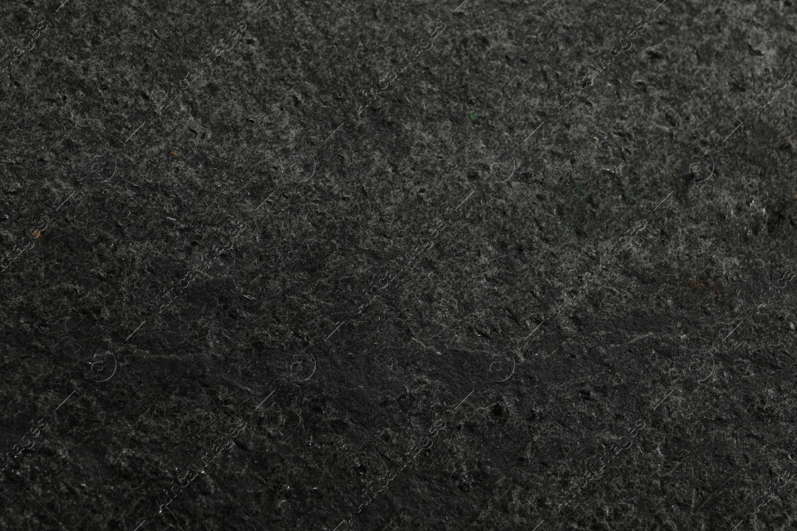 Photo of Texture of dark grey stone surface as background, closeup