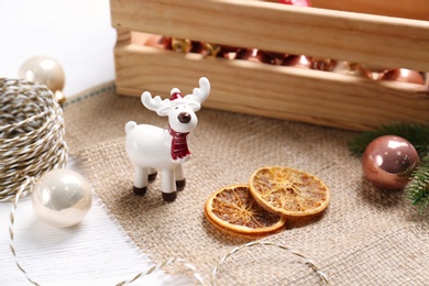 Photo of Composition with white deer and Christmas decor on table