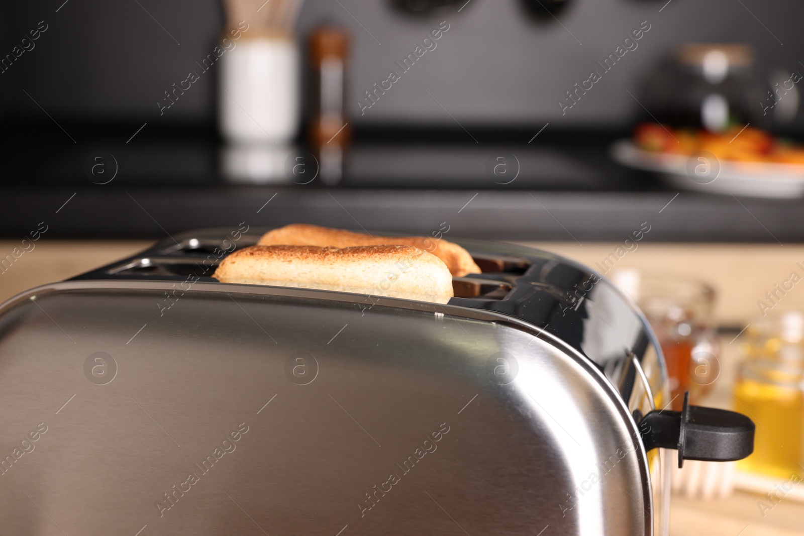 Photo of Toaster with tasty roasted bread in kitchen, closeup