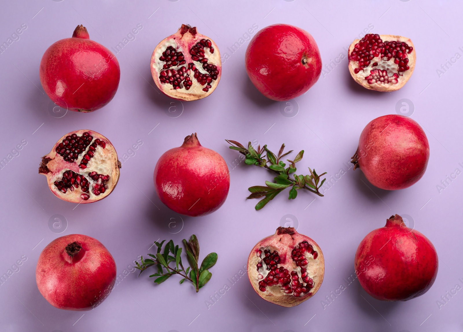 Photo of Flat lay composition with ripe pomegranates on violet background