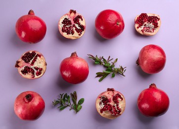 Flat lay composition with ripe pomegranates on violet background