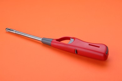 Photo of One bright gas lighter on orange background