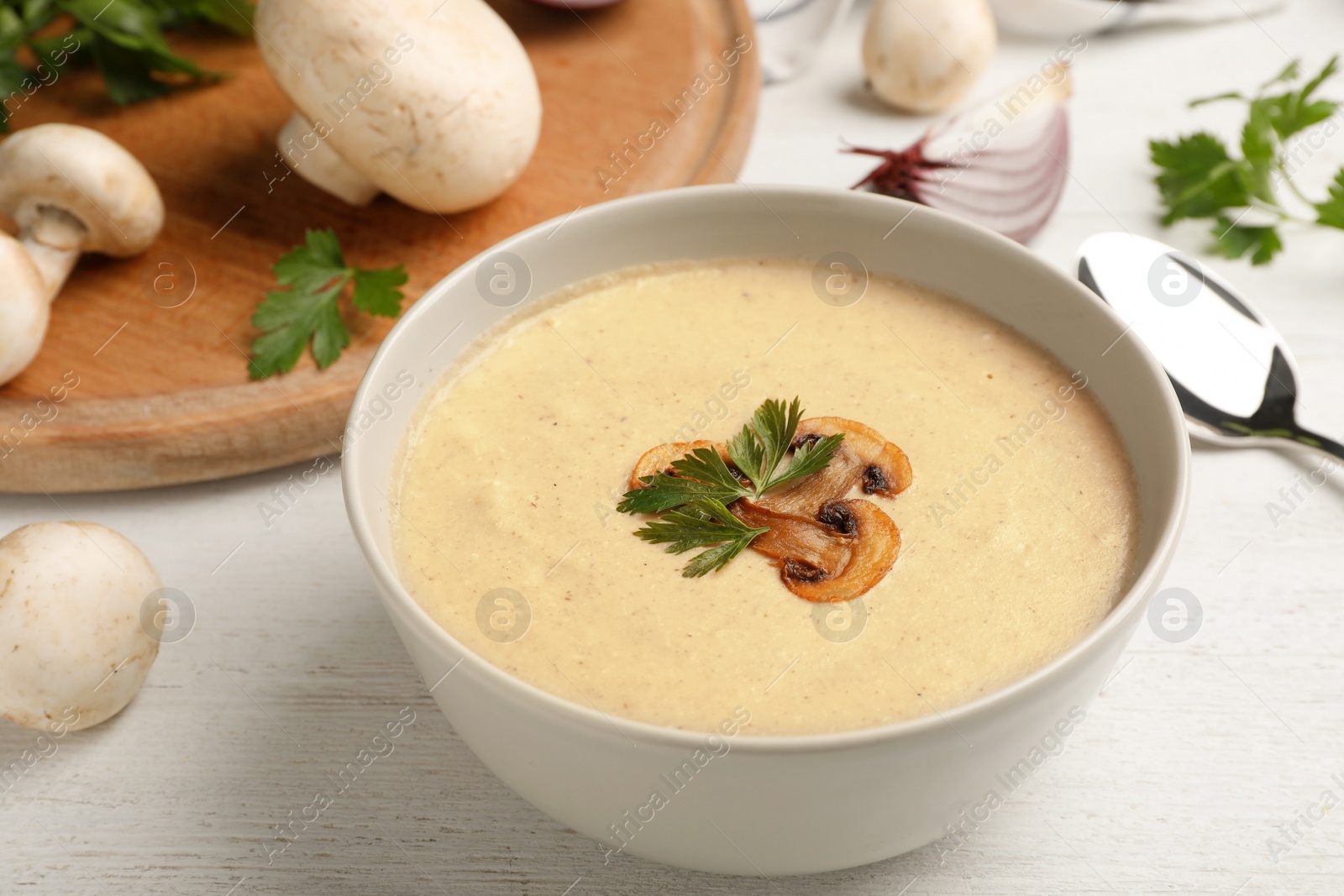 Photo of Bowl of fresh homemade mushroom soup on wooden table