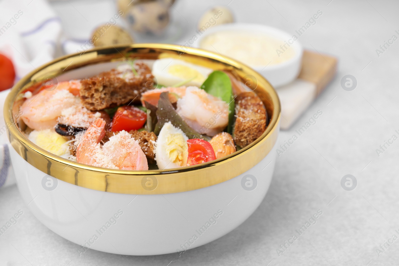 Photo of Delicious salad with croutons, tomatoes and shrimp served on white table, closeup. Space for text