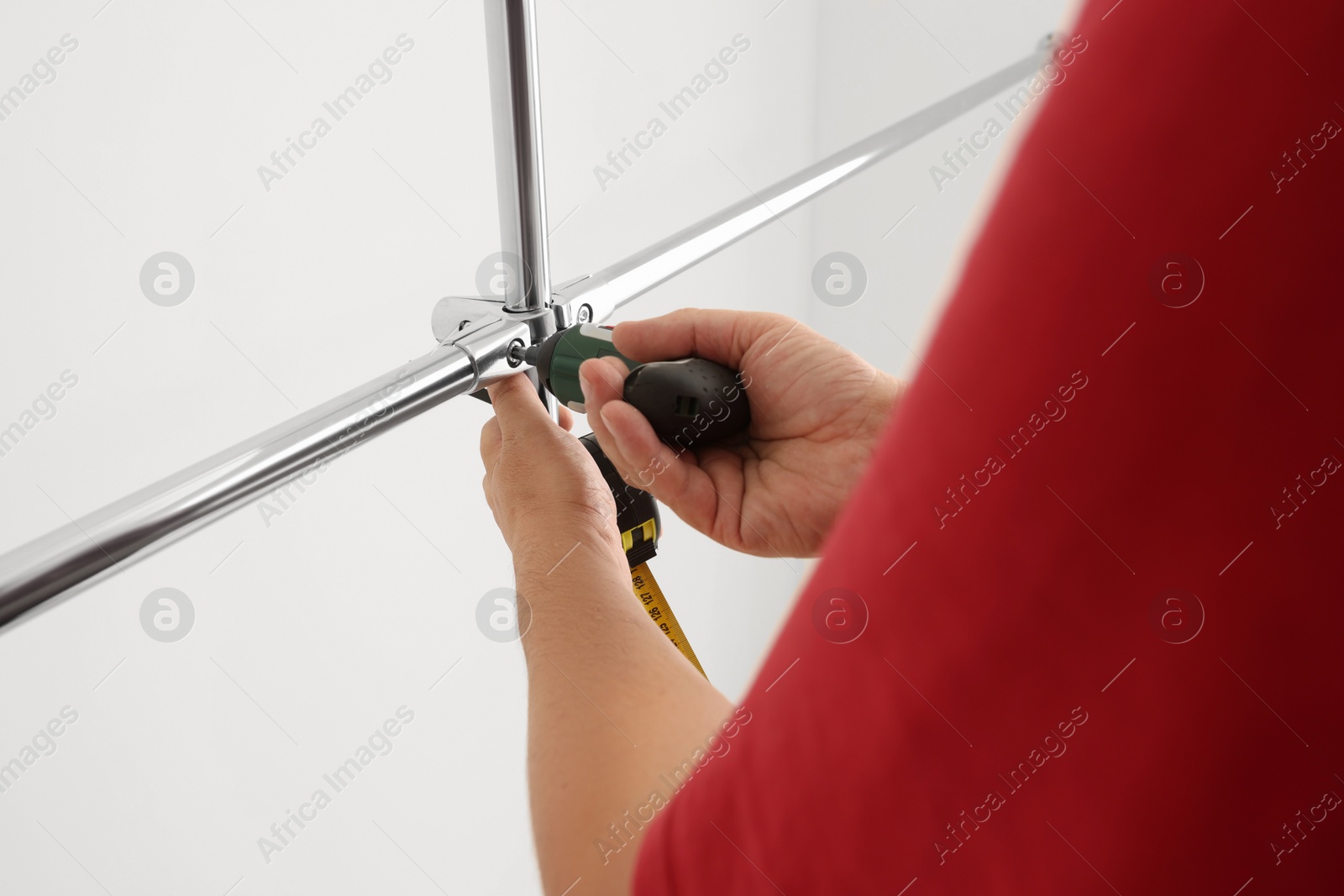 Photo of Worker installing new metal pipes with electric drill, closeup